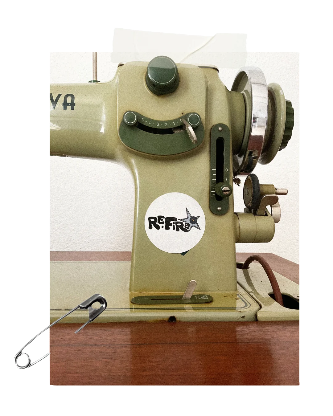Máquina de costura vintage verde com autocolante RE.FiRa e alfinete de dama.